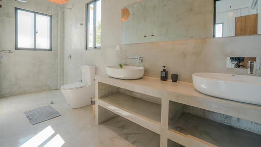 Modern bathroom with two white sinks on a wooden vanity, large mirror, and natural light.