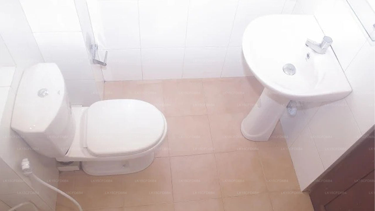Bathroom with toilet and sink on a tiled floor