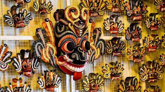 A collection of brightly colored and intricately designed traditional Sri Lankan masks displayed in a row.
